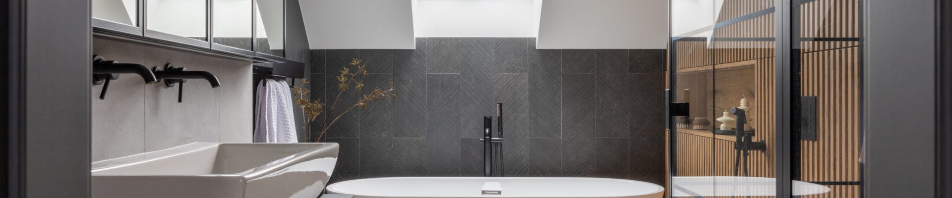 Stylish interior of bathroom with bathtub, shower, towels and ot Stylish interior of bathroom with bathtub, shower, towels and other personal bathroom accessories. Modern and design interior concept. Roof window. Template.